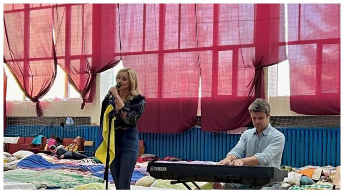 Ірина Федишин та Євген Хмара співають перед переселенцями