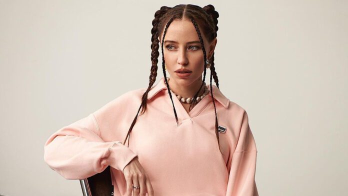 Вагітна Дорофєєва в довгій коричневій сорочці не приховала округлий живіт