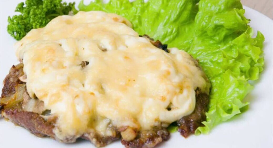 Таке мʼясо варто спробувати всім: запікаємо найсоковитішу свинину з сиром, грибами та соленими огірками 